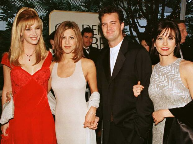 Matthew Perry y Jennifer Aniston tomados de la mano en una foto grupal con sus compañeros de "Friends" (Foto: AFP)