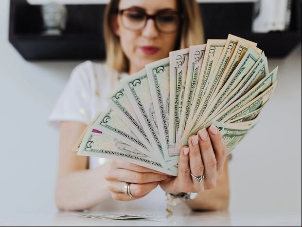 Una ciudadana contando sus billetes de dólar (Foto: Pexels)